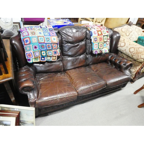 62 - A leather upholstered three seater settee.