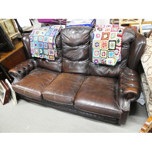 62 - A leather upholstered three seater settee.