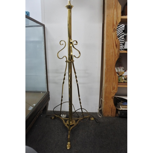 569 - A brass standard lamp and shade on tripod base, measuring 76