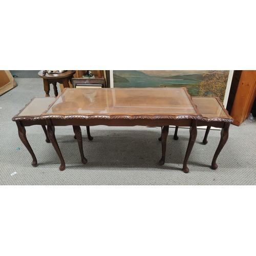 163 - A mahogany long nest of three tables with glass and leather top, measuring 37