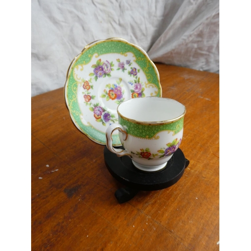 23 - A stunning Royal Albert Crown China miniature cabinet cup and saucer on a presentation stand.