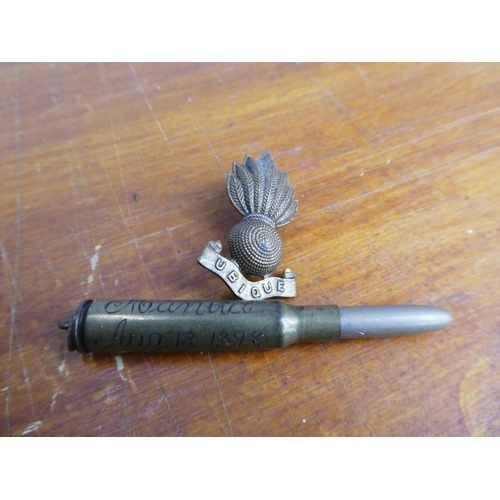 15 - A Royal Artillery brooch and an antique brass bullet, inscribed 'Manila, Aug 13 1898'.