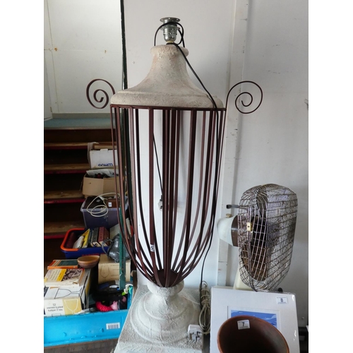 5 - A large floor standing lamp with metal framework.
