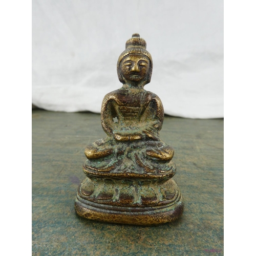 106 - A small brass ornament of a Buddha.