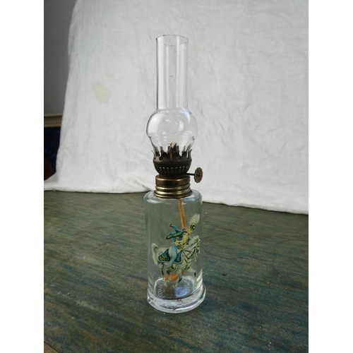 128 - A small clear glass oil lamp with a picture of a soldier on horseback.