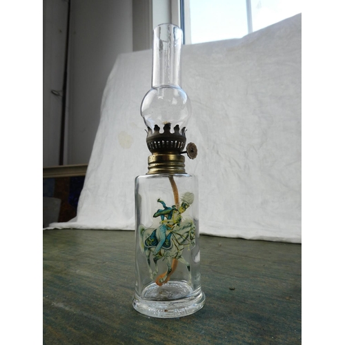 128 - A small clear glass oil lamp with a picture of a soldier on horseback.