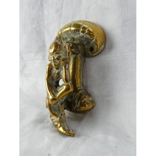 64 - A small brass cherub door knocker and two brass ornaments.