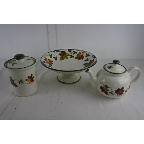 254 - A hand painted Poole Pottery teapot, fruit bowl and lidded container.