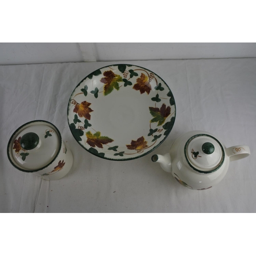 254 - A hand painted Poole Pottery teapot, fruit bowl and lidded container.