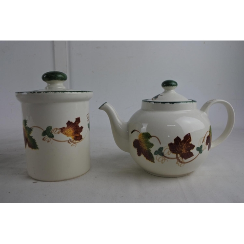 254 - A hand painted Poole Pottery teapot, fruit bowl and lidded container.