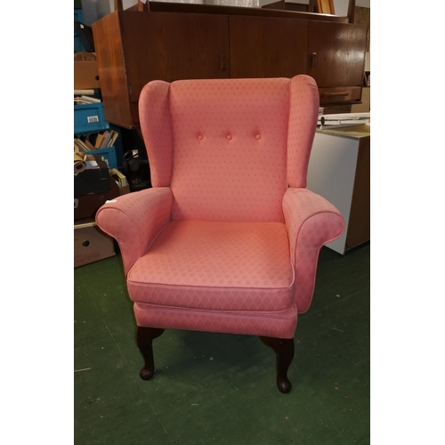 641 - A vintage wingback armchair.