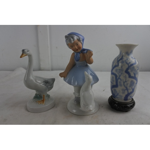 82 - A West German pottery figure of a girl with duck and more.