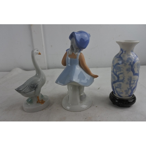 82 - A West German pottery figure of a girl with duck and more.