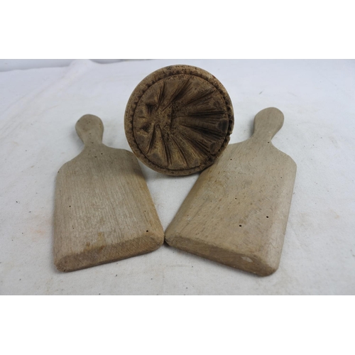 86 - An antique butter press and a pair of antique butter pats.