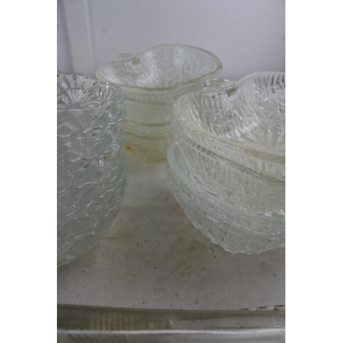 99 - An assortment of vintage glassware to include a butter dish, 'apple' sundae dishes and more.