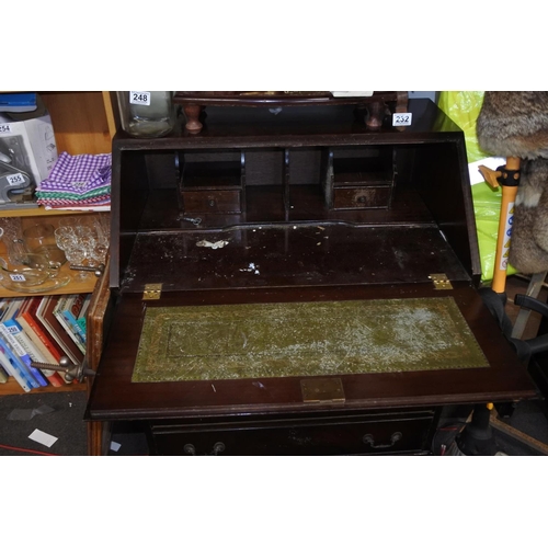 231 - An antique mahogany writing bureau and key.