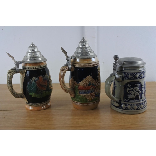 239 - Three decoative lidded tankards.