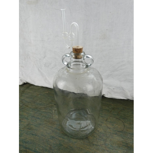 159 - A clear glass demijohn bottle and stopper.