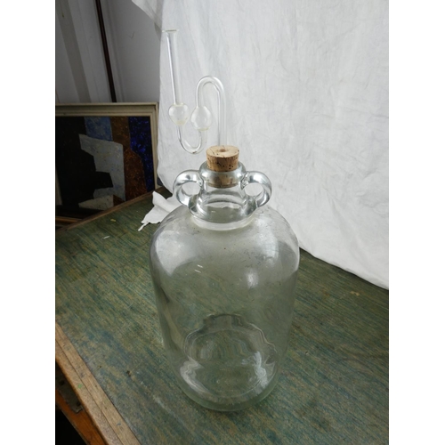 159 - A clear glass demijohn bottle and stopper.