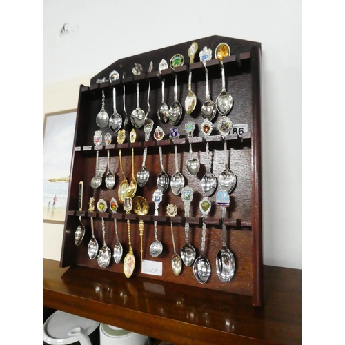 186 - A lot of souvenir spoons in a presentation wooden rack.