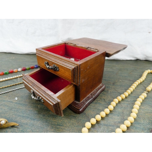 194 - A small wooden jewellery box and contents.