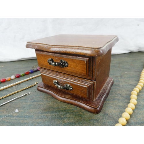 194 - A small wooden jewellery box and contents.