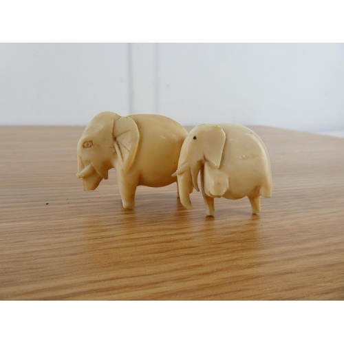 355 - Two antique hand carved bone elephants.