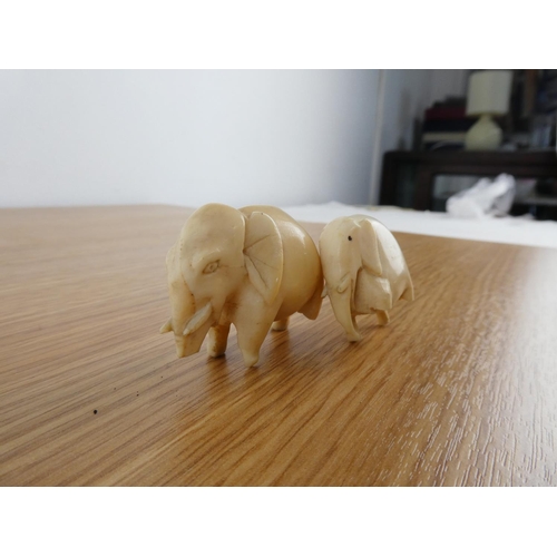 355 - Two antique hand carved bone elephants.