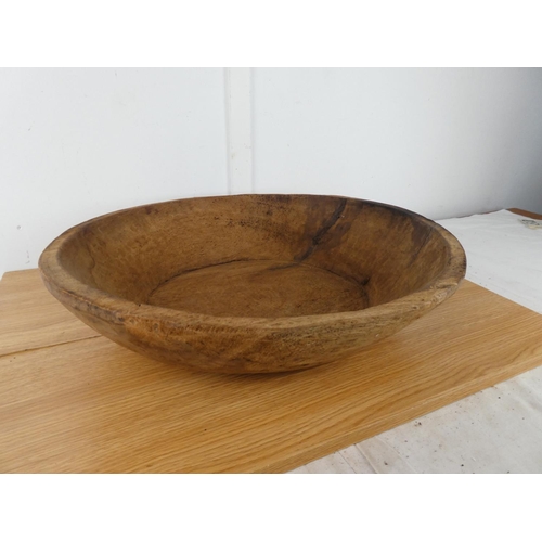 386 - A large antique wooden dairy bowl, measuring 50cm wide and 12cm tall.