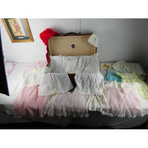 417 - A vintage luggage case containing a lot of child's baby clothes.