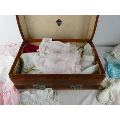 417 - A vintage luggage case containing a lot of child's baby clothes.