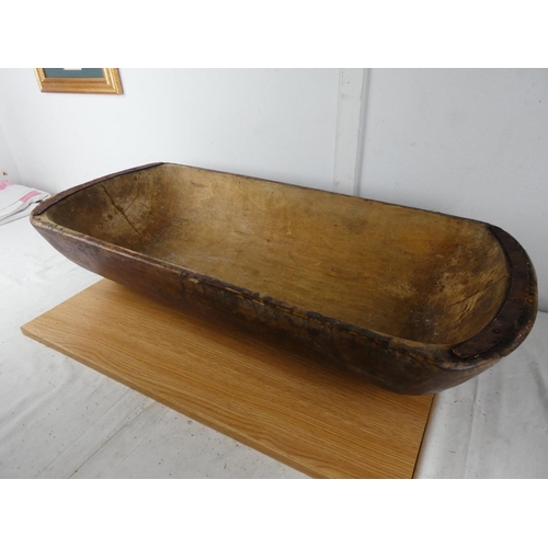 428 - A large antique dough bowl, measuring 90cm x 38cm x 18cm.