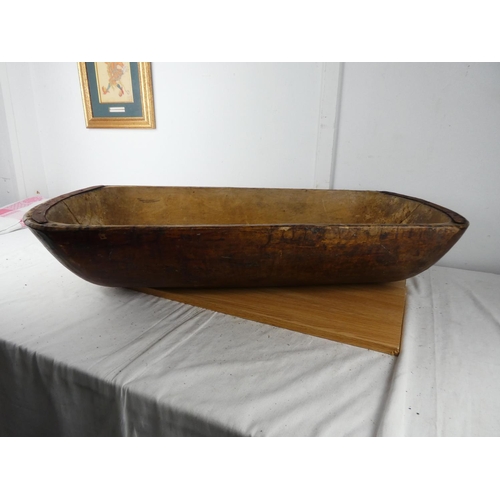 428 - A large antique dough bowl, measuring 90cm x 38cm x 18cm.