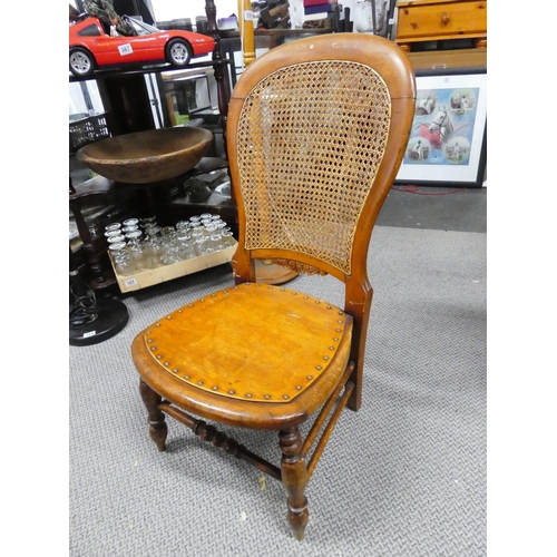 439 - A wooden chair with cane back detail.