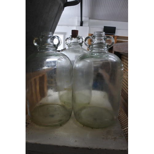 519 - Three clear glass demijohn bottles.