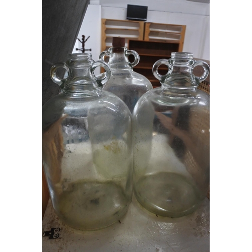 519 - Three clear glass demijohn bottles.