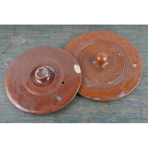 704 - An antique terracotta glazed lid and another.