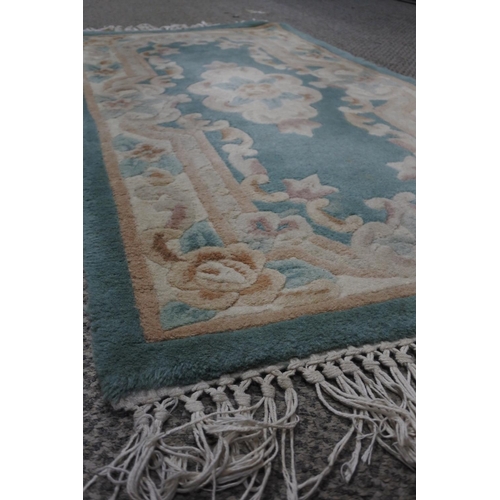 746 - A green and cream floral floor rug.