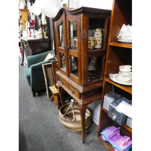 829 - A small wooden two door display cabinet with drawer, measuring 127cm x 59cm x 30cm approximately.