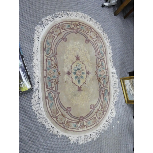 868 - An oval cream floral rug, measuring 160cm x 97cm.