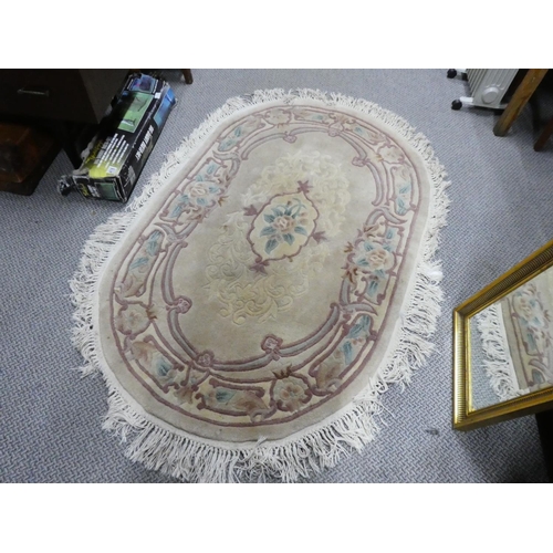 868 - An oval cream floral rug, measuring 160cm x 97cm.