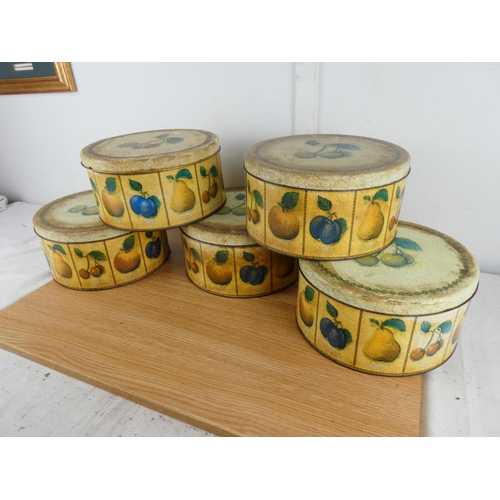 885 - A set of five lidded cake tins with fruit design.