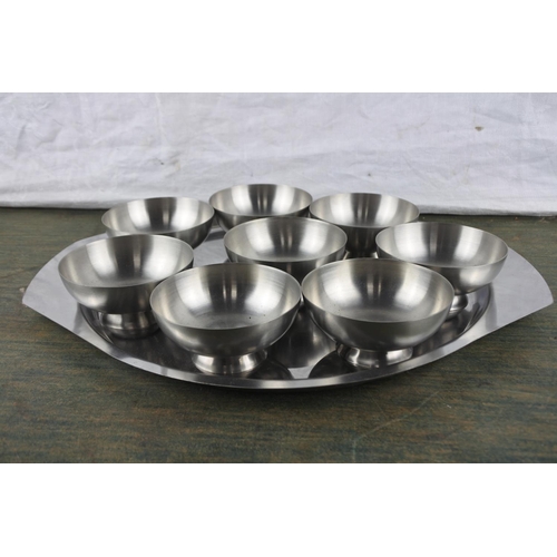 933 - A set of eight Viners stainless steel pudding bowl and a stainless steel serving tray.