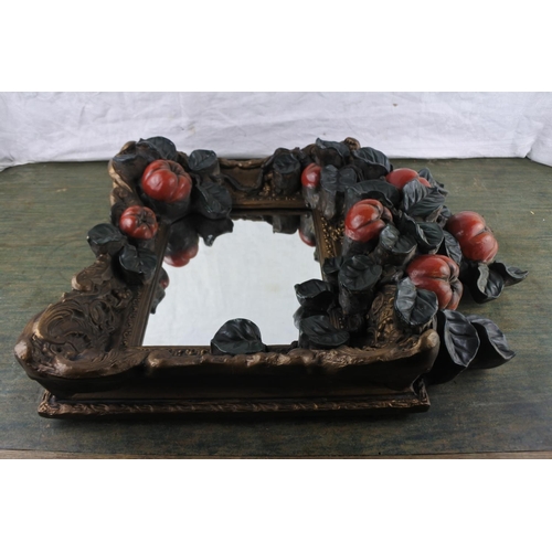 944 - A heavy wall mirror decorated with apples, measuring 50cm x 39cm x 10cm in size.