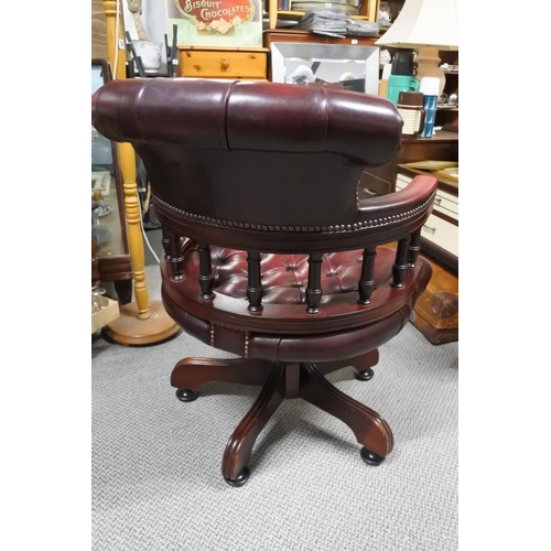 950 - A stunning upholstered ox blood leather captains swivel chair.