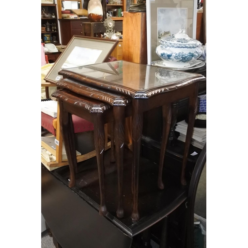 984 - A mahogany nest of tables with glass tops.