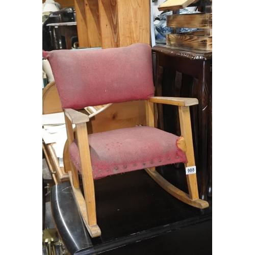 988 - A vintage child's rocking chair in need of upholstery.