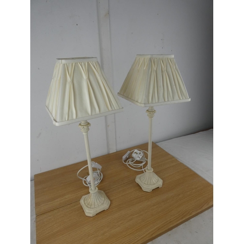 1055 - A pair of cream metal based table lamps and shades.