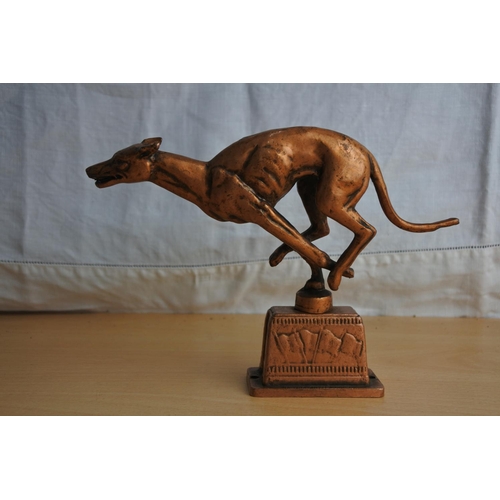 123 - A copper ornament of a greyhound racing dog.