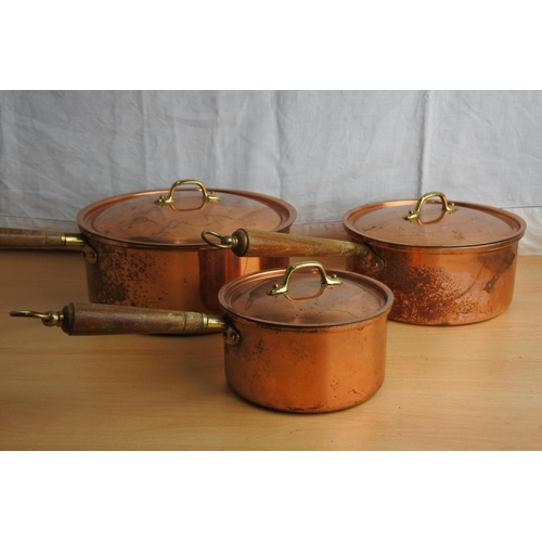 152 - A set of three copper lacquered lidded saucepans